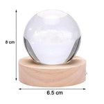 Hand holding the crystal ball lamp to show its compact size and portability.