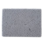 Close-up, top-down view of a rectangular gray cleaning block with a porous texture on a white background.