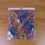 Hand holding multiple colorful printed fabric hair scrunchies