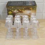 Ten clear acrylic miniature lamps are packaged in a clear plastic tray, positioned in front of a brown cardboard box.