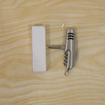 The silver multi-tool, with three black stripes on its handle, is shown with its knife, bottle opener, corkscrew, and awl