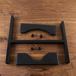 Disassembled black metal water bottle stand components, including two frame pieces, two cradles, and four small caps, lay on