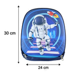 A young girl colors at a small wooden table, with the navy blue astronaut backpack resting on the floor beside her chair.