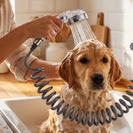 A golden retriever dog being bathed in a kitchen sink with the handheld shower spray, covered in white soap suds.