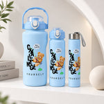 Three light blue water bottles of varying sizes with a teddy bear graphic and text on a white shelf.
