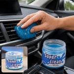 A hand presses blue cleaning gel into a car's air vent, with a jar of "Super Clean" gel in the foreground.