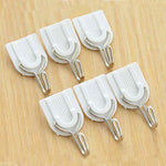 Self-adhesive hook blending seamlessly on a white tiled bathroom wall.