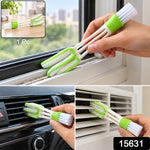 A hand holding a white and green 3-in-1 cleaning brush, using the microfiber side to clean a car vent.