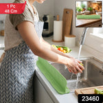Green silicone splash guard with suction cups for sink protection.