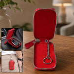 Red zippered leather car key case open, with a car key inside and another view of it clipped to pants.