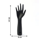 Black hand jewelry display stand placed on shelf for accessories