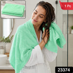 A woman in a white robe drying her wet hair with a light green towel, with a folded towel inset and product labels.