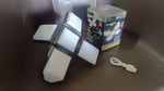 Foldable LED lantern in its expanded form, a white USB charging cable, and its product box on a dark surface.