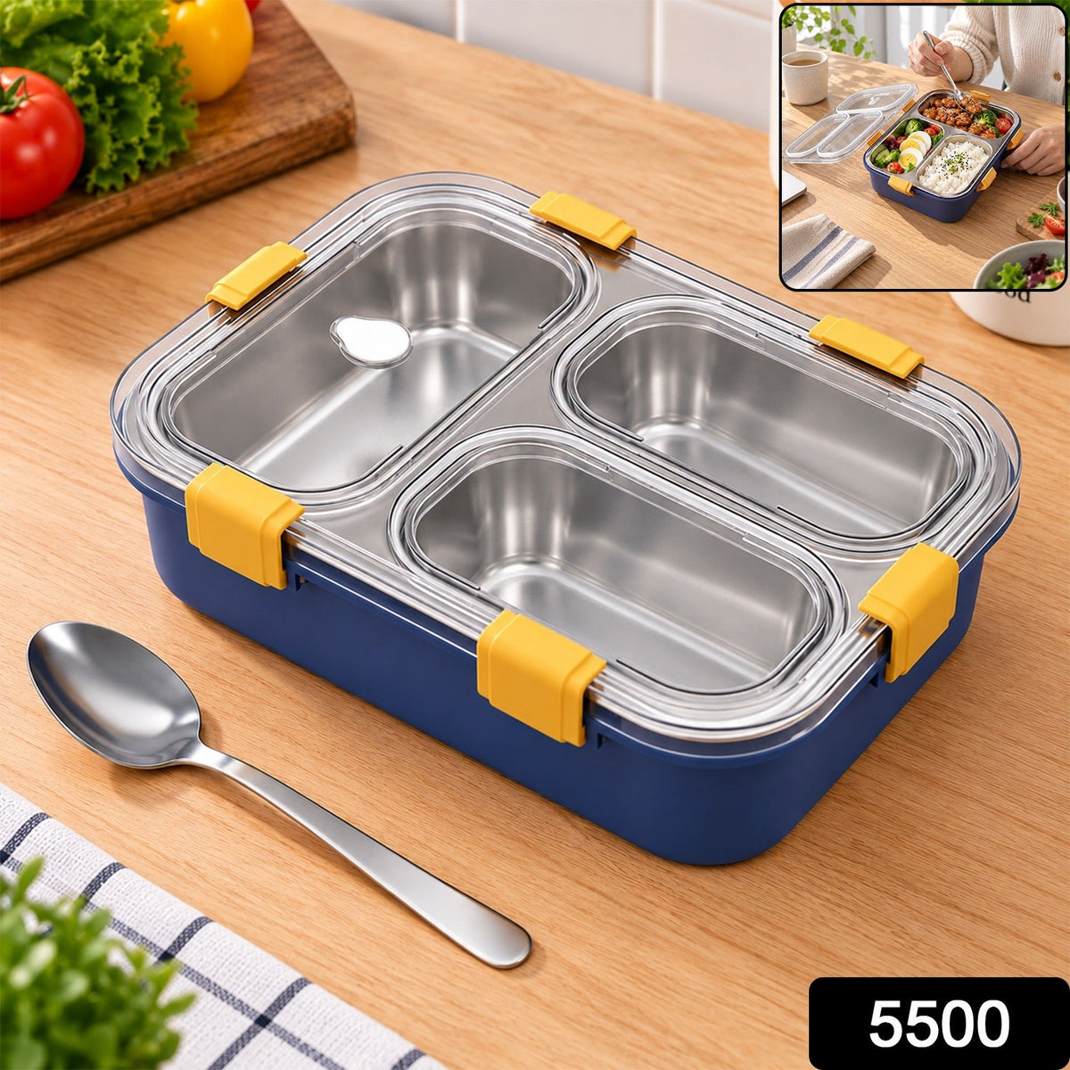 A blue lunch box with three stainless steel compartments and white clasps sits on a wooden table.