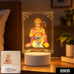 A bright Hanuman LED acrylic night lamp on a bedside table, with a small inset showing the lamp and USB cable.