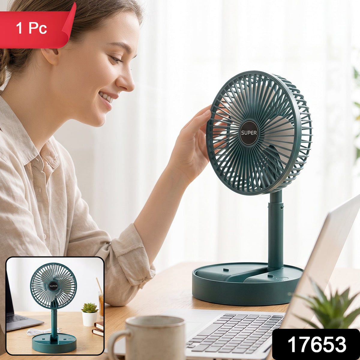 A dark green portable fan with a white USB cable on a wooden desk with a laptop and iced tea.