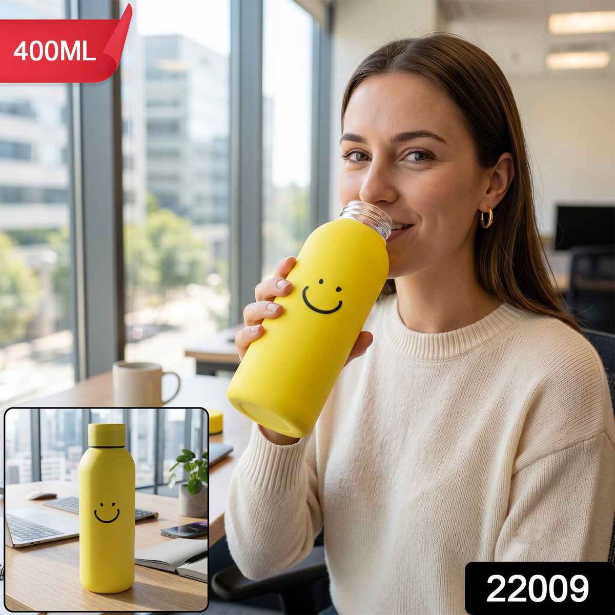 A woman in an office setting sips from a yellow glass water bottle with a smiley face onbottle.