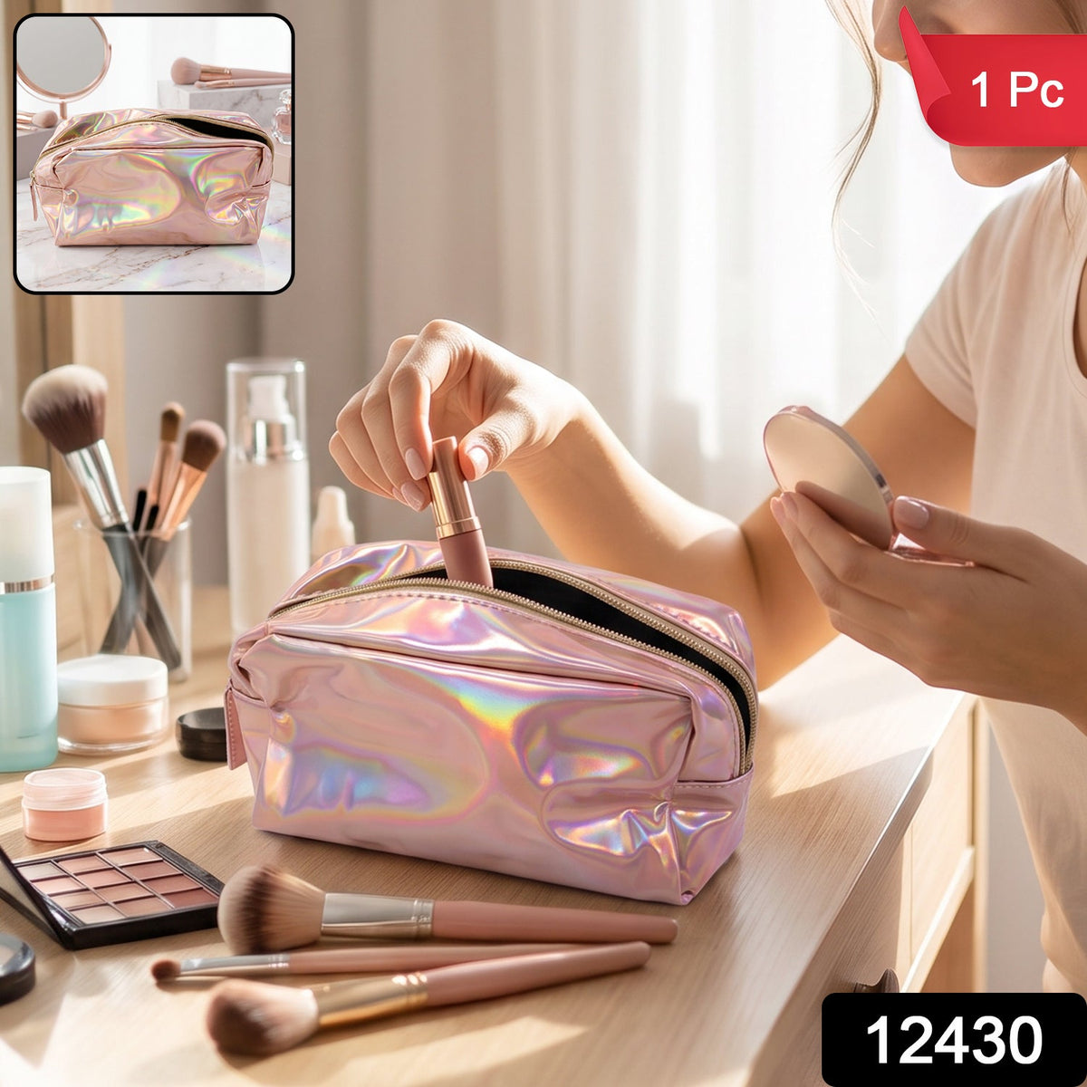 A holographic pink makeup bag with a zipper is open on a marble surface surrounded by makeup brushes and a mirror.