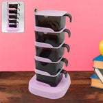 Rotating vertical spice rack with five clear sections and spoons on a kitchen counter.