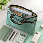 An open green patterned document bag filled with papers, notebooks, and a small pouch, surrounded by office supplies.