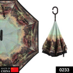 A partially open reverse umbrella with a dark landscape print, and a closed umbrella with a C-shaped handle.