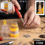 A person uses a red and black screwdriver to tighten a screw on a pair of glasses, with the screwdriver set
