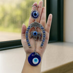 Close-up of alloy metal evil eye hanging with chain and elephant motif