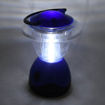 The blue and clear plastic lantern is brightly illuminated, casting a glow on the surrounding gray surface.