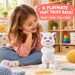 A young girl with long hair sits on a patterned rug, smiling at a white cat toy with pink ears and nose, with colorful toys
