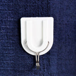 A small adhesive hook in a hallway, perfect for hanging keys and other small items.