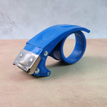Handheld heavy-duty tape gun with metal rivets and ergonomic handle