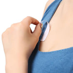 A hand applies a clear strip of tape to the blue fabric of a garment near the chest area.