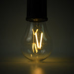 A close-up of the clear bulb of a portable LED tent light shows the glowing orange filament against a dark background.