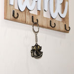 Hand holding Ganesh Face Antique Black Metal Keychain, highlighting portability