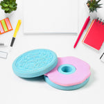 A disassembled blue and pink cookie eraser shows its two parts on a white desk with office supplies.
