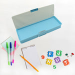 An open blue pencil case is surrounded by colorful pens, a small notebook, a pencil, and foam letter and number shapes.