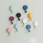 Pack of 10 transparent self-adhesive wall hooks on a white surface.