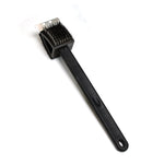 Black silicone toilet brush with its draining holder, ready for use in a modern bathroom.
