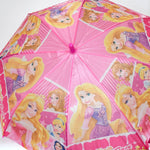 Close-up of the pink umbrella canopy showing multiple Disney Princess characters and text.