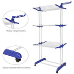 Foldable stainless steel clothes drying rack with wheels and side hanger arms holding garments indoors