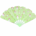 An open green plastic fan with a scalloped edge and a pattern of white bears and red apples.