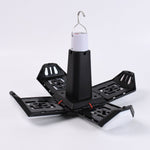 Foldable LED lantern in its expanded, open position with four white light panels extending from a black base.
