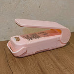 Hand holding the Mini Plastic Bag Sealer, highlighting its ergonomic design.