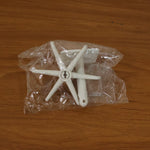 Versatile adhesive hook applied to a glass surface, holding various small items.