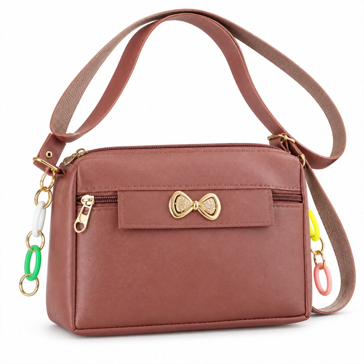 A mauve sling bag with a gold bow and colorful charms on a white background, angled view.