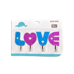 Multiple love shape self adhesive hooks organized on a kitchen wall.