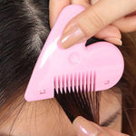 Child's hand holding pink heart-shaped safety hair scissors