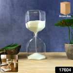 Minimalist glass hourglass sand timer placed on a wooden surface for focus and mindfulness