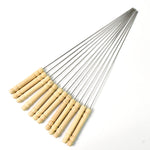 Durable stainless steel skewers laid out ready for grilling on a barbecue.