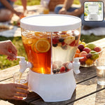A person dispenses iced tea from a clear plastic dual-compartment dispenser with white base and lid, filled with